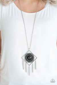 Sandstone Solstice - Black - Paparazzi Accessories  Radiating with studded details and earthy black stones, a round frame is nestled inside of an airy silver square for a tribal inspired look. Attached to a lengthened silver chain, the colorful stone pendant gives way to rows of silver chain fringe for a statement-making finish. Features an adjustable clasp closure.  Sold as one individual necklace. Includes one pair of matching earrings.