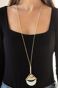 PAPARAZZI ACCESSORIES - Beach Beam - Gold - WHITE SHELL Threaded along dainty wires, rows of round white beads give way to a shell-like half moon pendant at the bottom of an angled gold frame. The beach inspired pendant is knotted in place at the bottom of a lengthened brown cord for a seasonal flair. Features an adjustable clasp closure.  Sold as one individual necklace. Includes one pair of matching earrings.