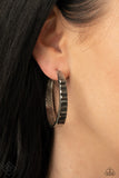 More To Love - Silver - Paparazzi Accessories -  Item #P5HO-SVXX-265ZU The top half of a thick textured silver frame is lined in a stack of emerald cut hematite rhinestones, creating an unexpected pop of shimmer. Earring attaches to a standard post fitting. Hoop measures approximately 1 3/4” in diameter.  Sold as one pair of hoop earrings.