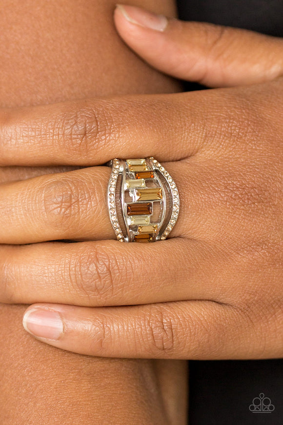 Treasure Chest Charm - Brown - Paparazzi Accessories  Topaz rhinestone encrusted bands flank a row of emerald cut glass beads in shades of brown and white for a regal look. Features a stretchy band for a flexible fit.  Sold as one individual ring.