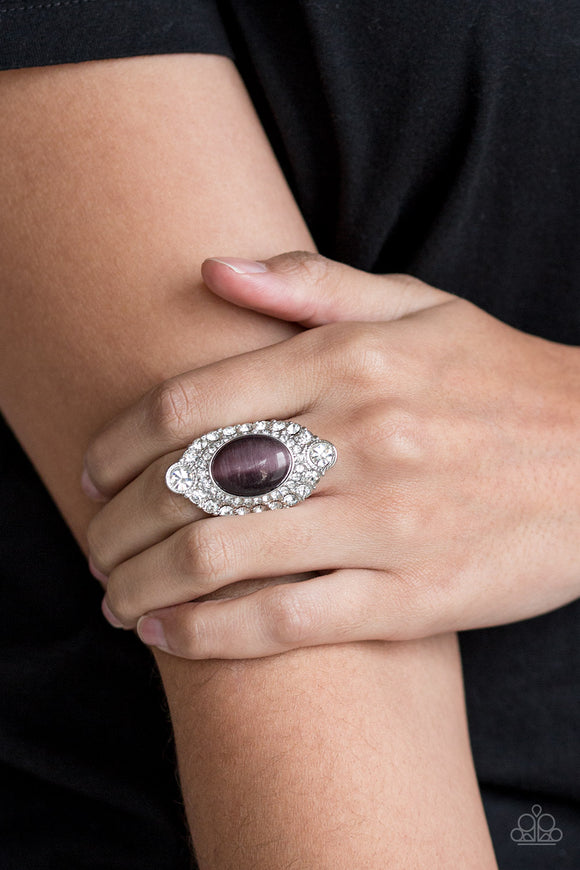 Riviera Royalty - Purple A glowing purple moonstone is pressed into a dramatic silver band radiating with glassy white rhinestones for a glamorous flair. Features a stretchy band for a flexible fit.  Sold as one individual ring.