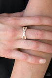 Extra Side Of Elegance - Rose Gold - Paparazzi Accessories Item #P4RE-GDRS-160XX Encrusted in dainty white rhinestones, glistening rose gold ribbons loop away from a dazzling white rhinestone center for a refined look. Features a dainty stretchy band for a flexible fit.  Sold as one individual ring.