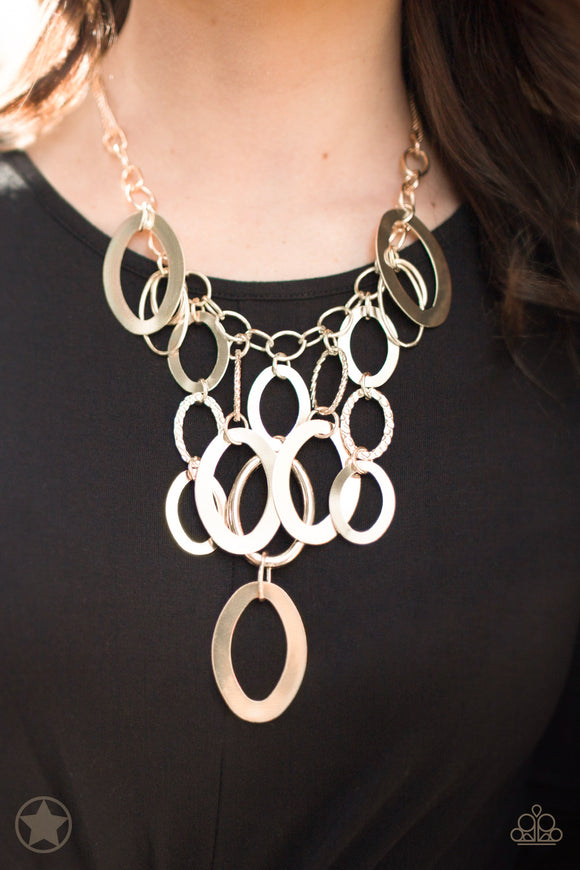 A Golden Spell - Paparazzi Accessories  Large gold links and shimmering textured gold rings cascade below a gold chain freely, allowing for movement that makes a bold statement. Features an adjustable clasp closure.  Sold as one individual necklace. Includes one pair of matching earring.