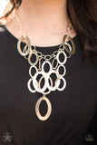 A Golden Spell - Paparazzi Accessories  Large gold links and shimmering textured gold rings cascade below a gold chain freely, allowing for movement that makes a bold statement. Features an adjustable clasp closure.  Sold as one individual necklace. Includes one pair of matching earring.