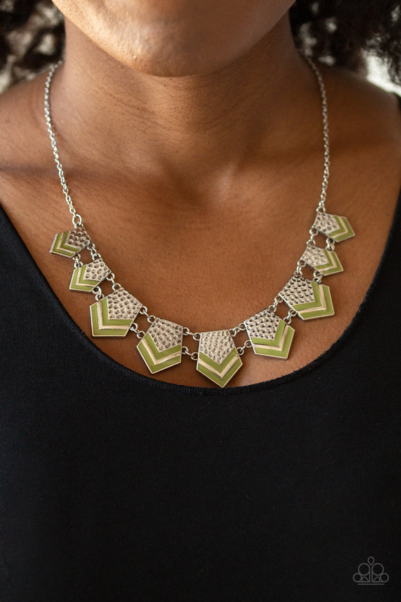Pack Princess - Green - Paparazzi Accessories -  P2TR-GRXX-072XX  Painted in earthy Guacamole accents, a collection of hammered geometric plates gradually increase in size as they fan out below the collar for a fierce tribal look. Features an adjustable clasp closure.  Sold as one individual necklace. Includes one pair of matching earrings.