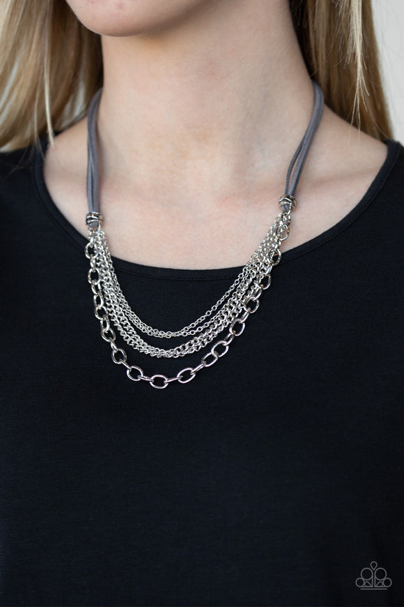 Free Roamer - Silver - Paparazzi Accessories  Suspended between strips of earthy gray suede, mismatched strands of silver layer below the collar for a spunky industrial look. Features an adjustable clasp closure.  Sold as one individual necklace. Includes one pair of matching earrings.