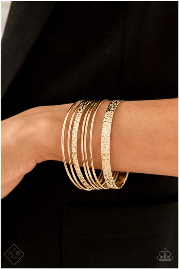 A Full Circle - Gold - Paparazzi Accessories -  Brushed in a high-sheen shimmer, a collection of smooth and heavily textured gold bangles slides up and down the wrist for an edgy stacked look.