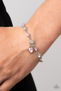 Truly Lovely - Pink - Paparazzi Accessories -   Item #P9WH-PKXX-294FF A pink rhinestone heart charm dances from a strand of white and pink rhinestones, resulting in a flirtatious sparkle around the wrist. Features an adjustable clasp closure.  Sold as one individual bracelet.