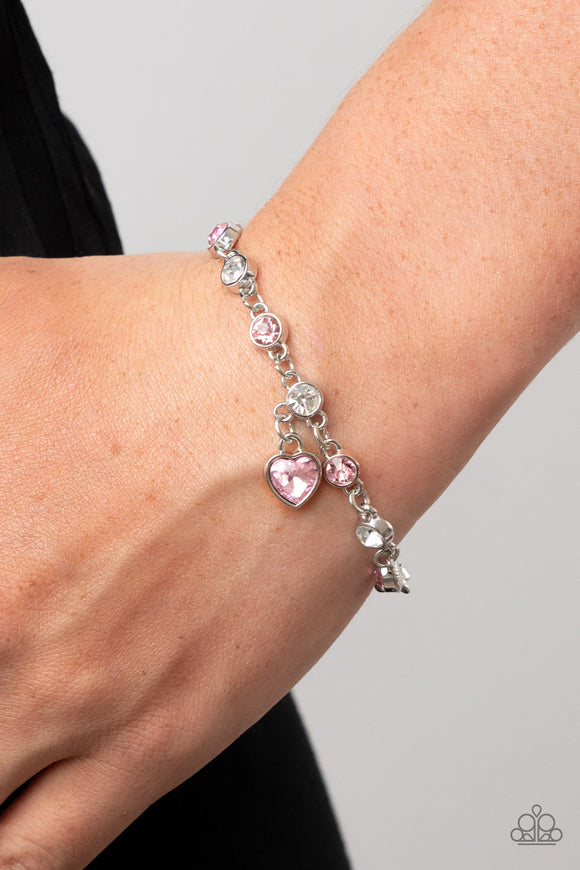 Truly Lovely - Pink - Paparazzi Accessories -   Item #P9WH-PKXX-294FF A pink rhinestone heart charm dances from a strand of white and pink rhinestones, resulting in a flirtatious sparkle around the wrist. Features an adjustable clasp closure.  Sold as one individual bracelet.