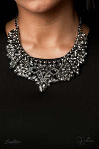 The Tina - 2020 Zi Signature - Paparazzi Accessories  An infinite display of smoky marquise cut rhinestones and dazzling hematite rhinestones meticulously join into three dramatically dazzling frames below the collar. Attached to classic gunmetal chains, the dauntless display of dazzle cascades into an oversized smoky teardrop at the bottom, stealing the spotlight. Features an adjustable clasp closure.  Named after 2020 Rock the Runway winner, Tina P.  Sold as one individual necklace. Includes one pair of m