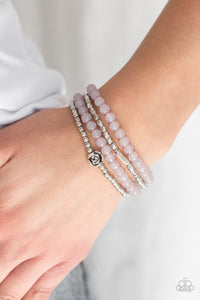 Blooming Buttercups - Silver - Paparazzi Accessories  Mismatched silver beads and strands of glassy gray beads are threaded along stretchy bands. Infused with silver accents, dainty rose blossoms adorn the wrist for a seasonal finish.  Sold as one set of four bracelets.