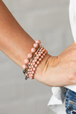 Vibrantly Vintage - Pink - Paparazzi Accessories Item #P9WH-PKXX-250XX Infused with dainty silver beads, a mismatched collection of Rose Tan and shiny silver beads are threaded along stretchy bands around the wrist for a colorfully layered look.  Sold as one set of five bracelets.