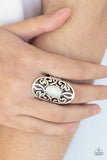 GLEAM Big - White A glowing white cat's eye stone is pressed into the center of an oval backdrop swirling with vine-like filigree for a whimsical look. Features a stretchy band for a flexible fit.  Sold as one individual ring.