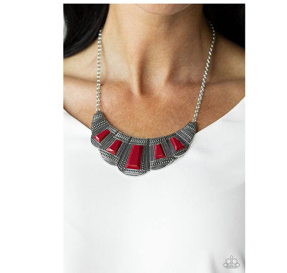 Lion Den - Red - Paparazzi Accessories -  Featuring faceted emerald style cuts, bold geometric red beads are pressed into studded silver frames that dramatically link below the collar for a fierce finish. Features an adjustable clasp closure.  Sold as one individual necklace. Includes one pair of matching earrings.