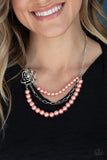 Fabulously Floral - Orange - Paparazzi Accessories  Dotted with a glassy white rhinestone center, an airy silver floral frame gives way to layers of coral pearls and a shiny row of silver chain below the collar for a whimsically refined look. Features an adjustable clasp closure.  Sold as one individual necklace. Includes one pair of matching earrings.